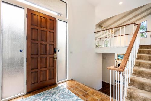 a hallway with a wooden door and a staircase at Heavenly Carmel - Stay for 10 in Carmel