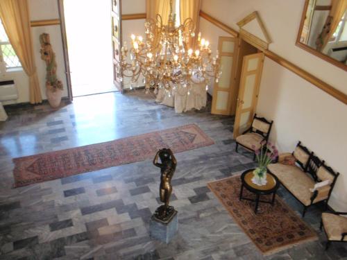 a lobby with a chandelier and a statue in the middle at Villa Carrer in Porto Viro