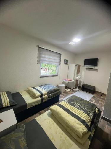 a bedroom with two beds and a flat screen tv at Apartments Daut's Tower in Sarajevo