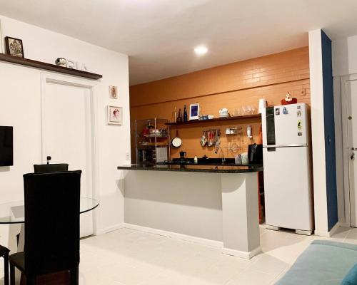 a kitchen with a white refrigerator and a counter at Quarto e Sala Temporada no Rio Vermelho in Salvador