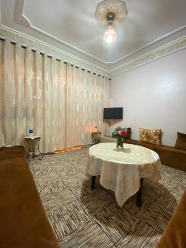 a living room with a table and a couch at Guest House Abde Rrahim Baallal in Skoura