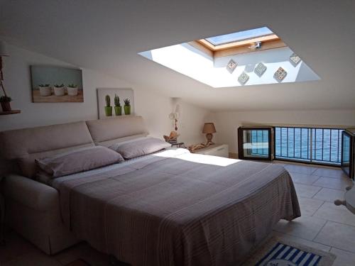 a bedroom with a large bed with a skylight at Villa Bella Sera in Scilla