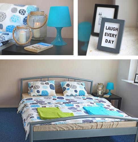 a bedroom with a bed with a blue lamp and a sign at HELLO Gdynia Hostel in Gdynia