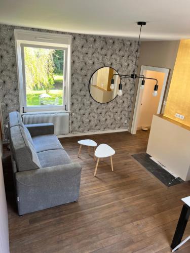 a living room with a couch and a mirror at Place de la gare cy in Commercy