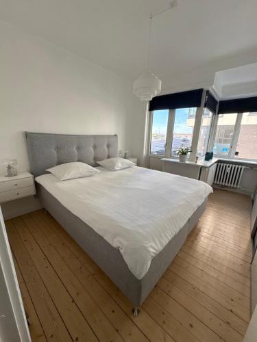 a bedroom with a large white bed and windows at Andra in Aalborg