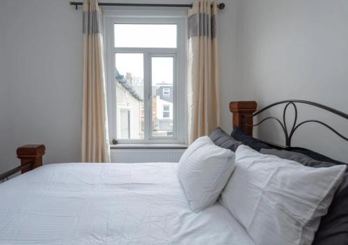 a bedroom with a white bed with a window at The Liddington in London