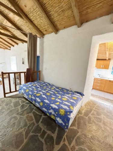 a bed in a room with a blue blanket at Happynest Leni, Stone House in Dhernikaíika