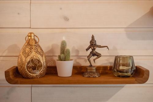 a shelf with a figurine and a candle and cactus at Kisvacok tiny house in Kismaros