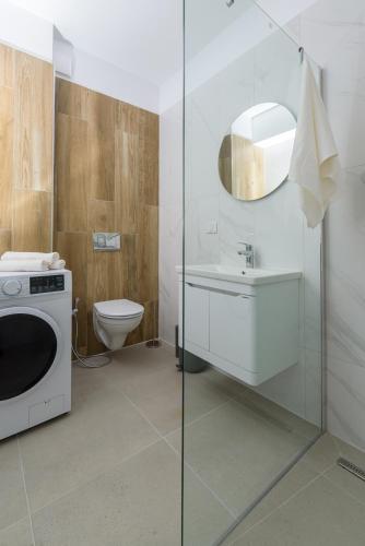 a bathroom with a sink and a washing machine at Hubix Suites - City of Mara in Timişoara