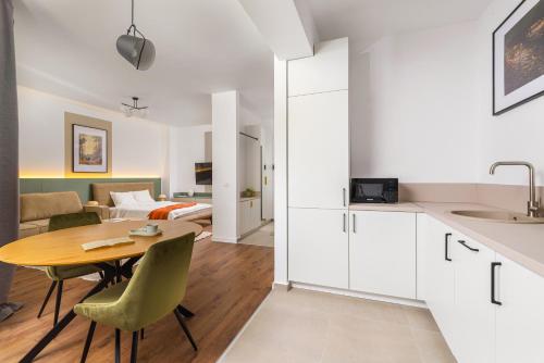 a kitchen and living room with a table and a bed at Hubix Suites - City of Mara in Timişoara