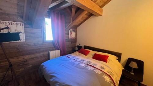 une chambre avec un lit avec des oreillers rouges et une fenêtre dans l'établissement Résidence Loup Dore - Appartement prestige - Plein sud - Face aux pistes - 9 Pers. MAE-0233, à Montgenèvre