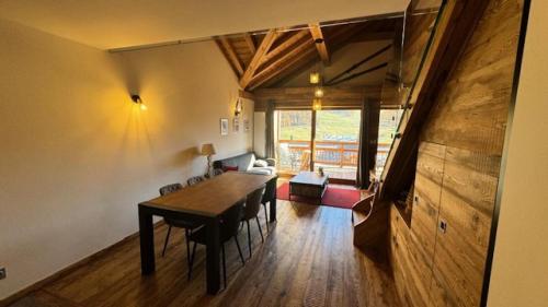 une salle à manger avec une table et des chaises dans une pièce dans l'établissement Résidence Loup Dore - Appartement prestige - Plein sud - Face aux pistes - 9 Pers. MAE-0233, à Montgenèvre