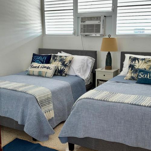 zwei nebeneinander stehende Betten in einem Schlafzimmer in der Unterkunft Oceanview Apartment Steps to the Beach in Luquillo