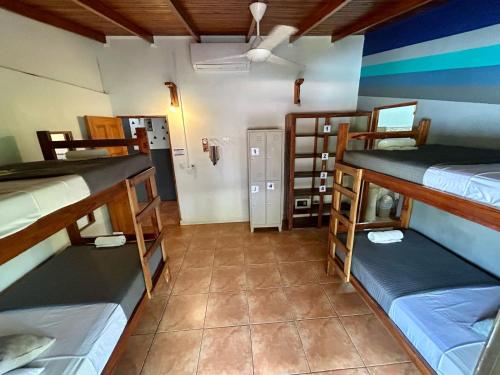 a room with three bunk beds in a room at Point Break Santa Teresa in Santa Teresa Beach