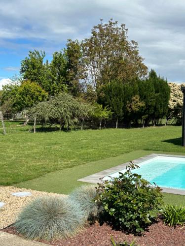 une cour avec une piscine et quelques plantes dans l'établissement Les Agapanthes chambres d hôtes, à Lamonzie-Saint-Martin