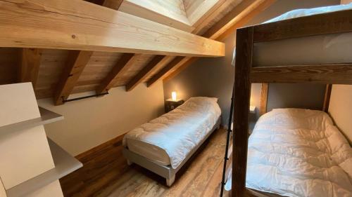 Cette chambre dispose de 2 lits superposés et de plafonds en bois. dans l'établissement Résidence Loup Dore - Appartement prestige - Plein sud - 90m² - Face aux pistes - 9 Pers. MAE-0243, à Montgenèvre