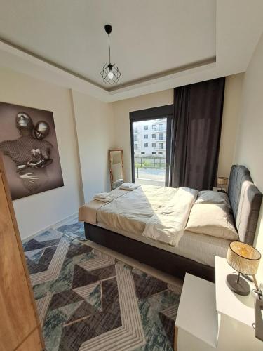 ein Schlafzimmer mit einem großen Bett und einem Fenster in der Unterkunft Neridabeachhomes 17 in Alanya