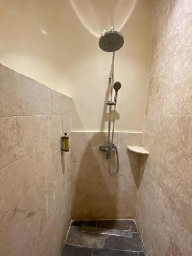 a shower in a bathroom with a stone wall at Boutique Hotel Casa Grande, Mango Tango Suite in Santo Domingo