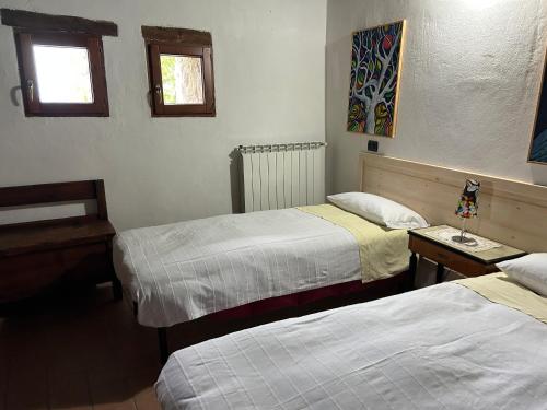 a hotel room with two beds and two windows at B&B Il Tempo Ritrovato in Canossa