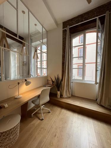 Cette chambre comprend un bureau avec une chaise et un miroir. dans l'établissement Rénovation d'architecte dans le cœur historique de Toulouse, à Toulouse