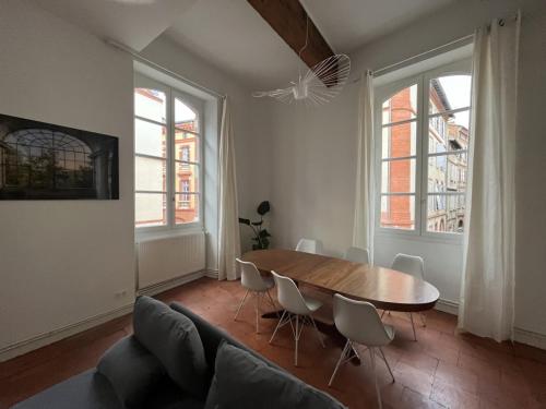 un salon avec une table et des chaises en bois dans l'établissement Rénovation d'architecte dans le cœur historique de Toulouse, à Toulouse