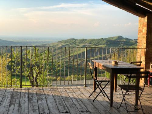 a wooden table and chairs on a balcony with a view at B&B Il Tempo Ritrovato in Canossa