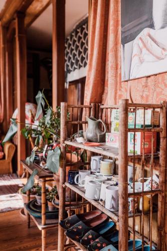 une pièce avec des étagères en bois remplies de vaisselle dans l'établissement La Villa Louis, maison d'hôtes, vue mer, à Lion-sur-Mer