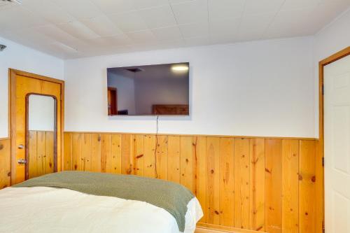 a bedroom with wood paneled walls and a mirror at 2 Mi to Black Hills Natl Forest Convenient Pad! in Spearfish