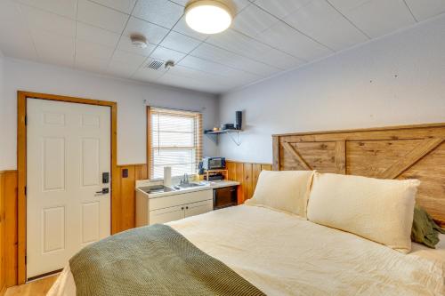 a bedroom with a bed and a kitchen with a sink at 2 Mi to Black Hills Natl Forest Convenient Pad! in Spearfish