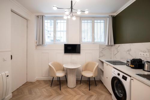 - une cuisine avec une table, 2 chaises et un évier dans l'établissement Charmant studio à Pigalle, à Paris