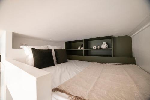 une chambre avec un lit avec des oreillers noirs et blancs dans l'établissement Charmant studio à Pigalle, à Paris