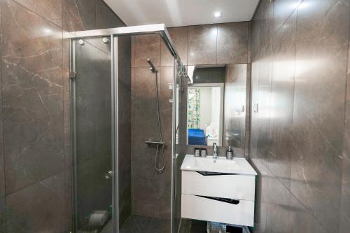 a bathroom with a shower and a sink and a mirror at Casa dos Terraços Apartamentos in São Martinho do Porto