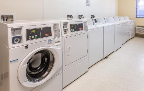 a row of white washing machines in a laundry room at My Place Hotel-Dickinson, ND in Dickinson