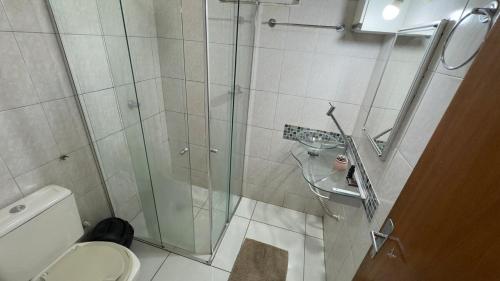 a bathroom with a glass shower with a toilet at Casa da Sementes in Uberlândia