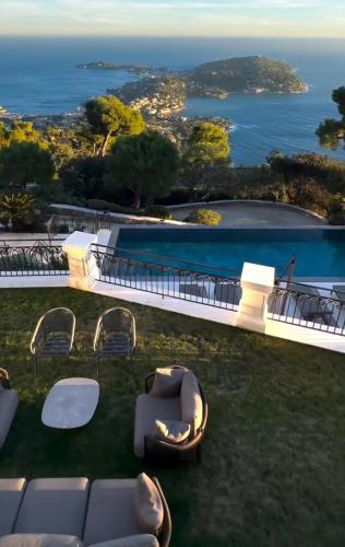 - une vue sur la piscine avec des chaises et un canapé dans l'établissement location villa cote, à La Celle-sous-Gouzon
