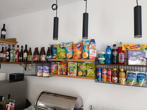 a kitchen counter with food and drinks on shelves at Pokoje u Daniela in Miedzygorze