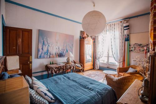 ein Schlafzimmer mit einem Bett und einem Tisch darin in der Unterkunft La Villa Louis, maison d'hôtes, vue mer in Lion-sur-Mer