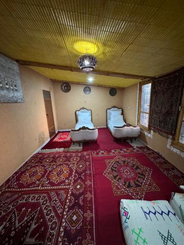a room with two beds and a red carpet at Villa Mouloud, arougou khenifra in Arrougou