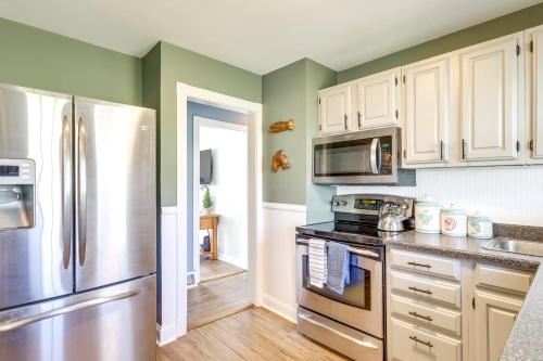 a kitchen with white cabinets and a stainless steel refrigerator at Walk to Private Beach and Boat Launch Mayfield Home in Broadalbin