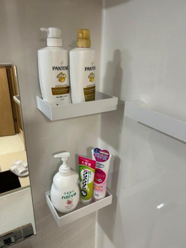 a bathroom shelf with bottles of laundry detergent and cosmetics at 高島市一棟貸切貸別荘グループファミリーok 大人数でご利用だとお得連泊がお得BBQ可能自転車無料利用可ペット可 in Takashima