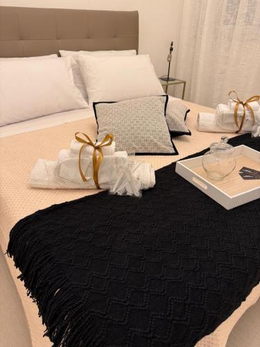 a bed with a black blanket and a tray on it at MARIANTONIA Apartment And Rooms in Reggio Calabria