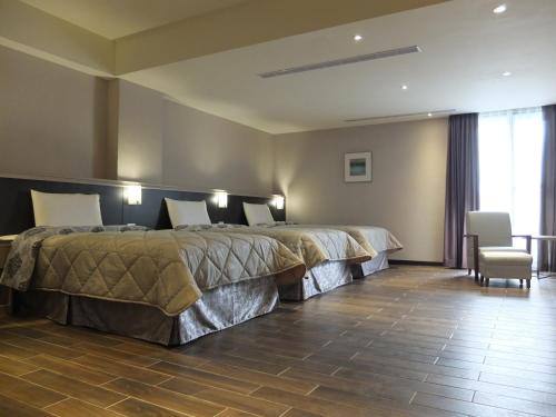 a hotel room with a large bed and a chair at VeryGood Business Hotel in Huatan