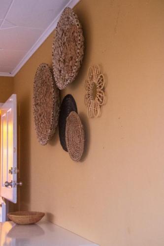 a wall with three hats hanging on a wall at Kunukuhuis Hofi Abundansia in Willemstad
