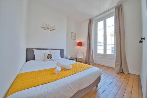 een slaapkamer met een groot bed met handdoeken erop bij Papeete 3 bedrooms in Reims