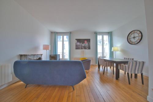 un salon avec un canapé bleu et une table dans l'établissement Papeete 3 bedrooms, à Reims