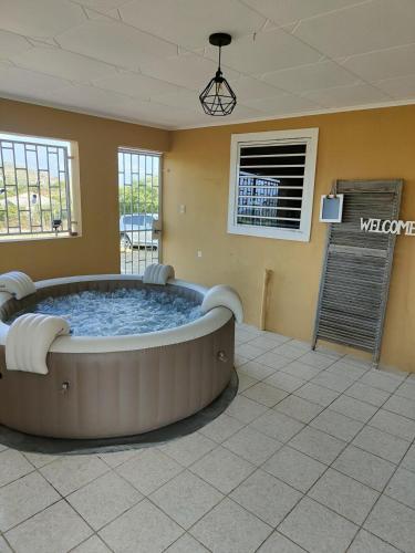 a large room with a hot tub in a living room at Kunukuhuis Hofi Abundansia in Willemstad