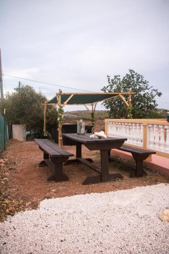 a picnic table and a bench in a yard at Kunukuhuis Hofi Abundansia in Willemstad