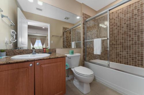 a bathroom with a toilet and a sink and a shower at King Queen Spacious Studio Near Universal in Orlando
