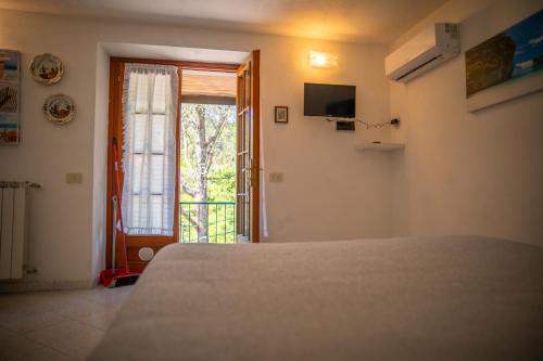 a bedroom with a bed and a door to a balcony at L'ulivo in Levanto