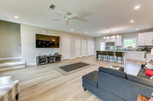 a living room with a couch and a kitchen at 4 Mi to Auburn University Townhome with Fenced Yard in Opelika